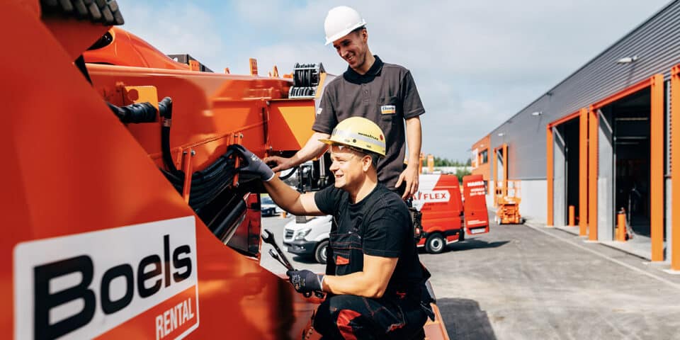 Zwei Mitarbeiter outdoor arbeiten an hydraulischem Gerät mit technischen Informationen und Service Paketen